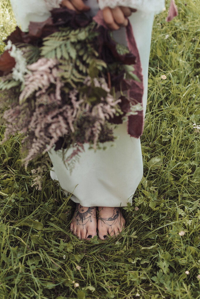 Nackte Füße zum Boho-Brautkleid, Brautstrauß in Beerentönen mit Prachtspiere