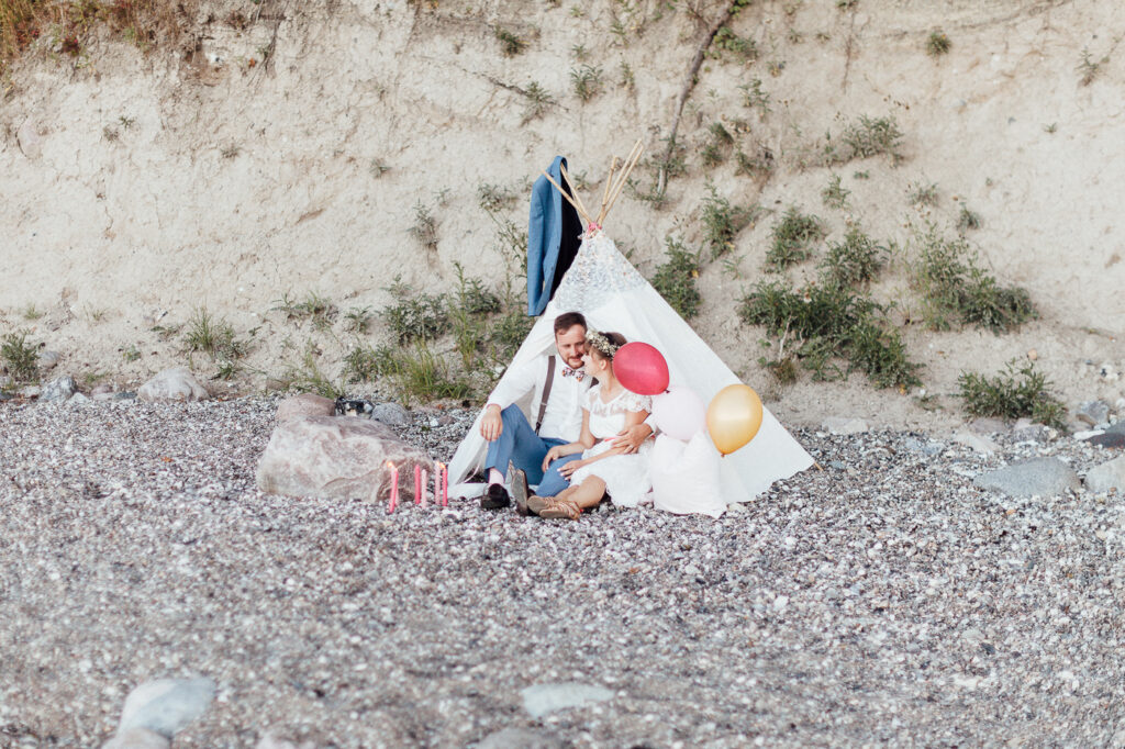 Vintage-Hochzeit auf Fehmarn, Brautpaar am Strand in einem Spitzentipi