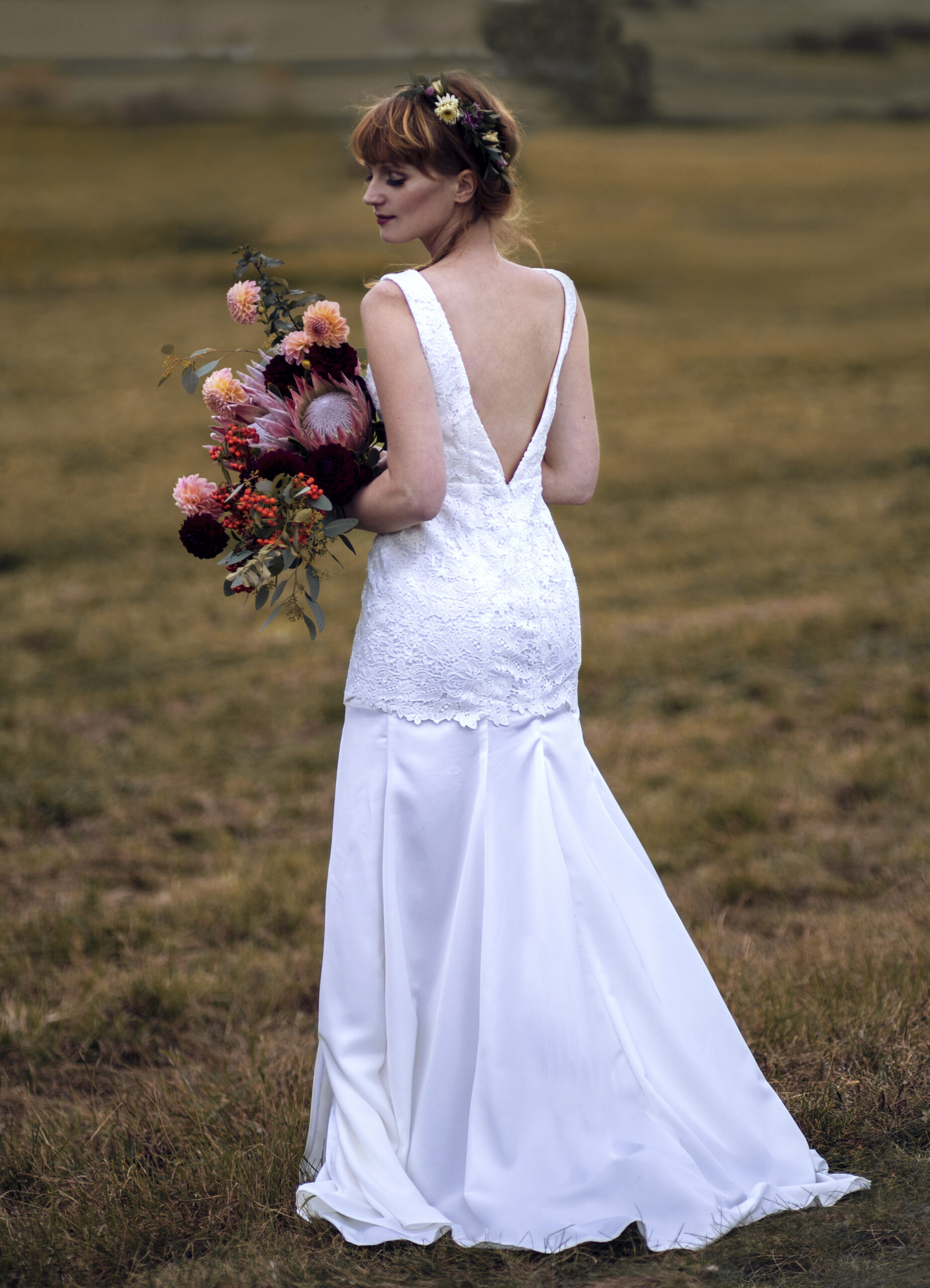 Brautkleid mit tiefem Rückenausschnitt im Boho-Stil, Brautstrauß in Blush und Bordeaux mit Protea und Dahlien